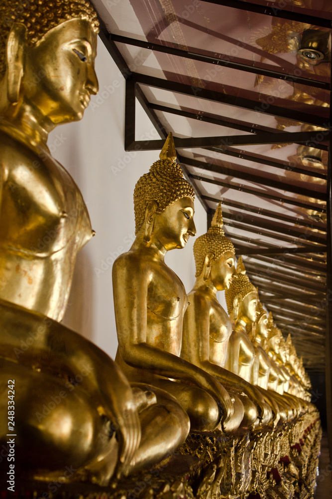 Many golden Buddha statues in Thai temple