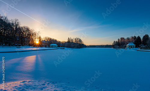 Winter sunrise over a snow-covered lake © photoff