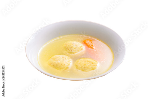 Traditional matzoh ball (kneidlach) soup.White bowl with authentic matzo ball chicken taste hot soup ( bouillon ) isolated on white background. Jewish food for Passover and every day.