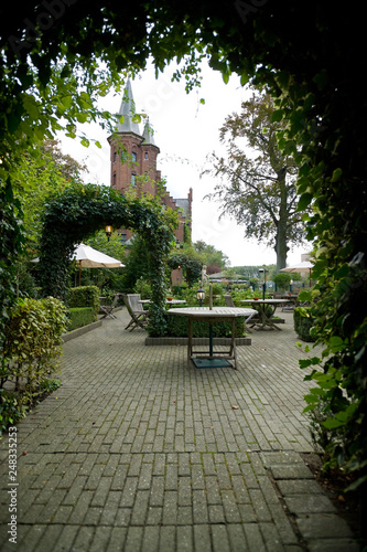 empty cafe tables in front of historic building in Brugge