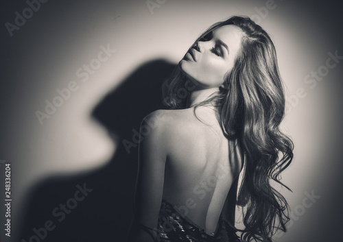 Sexy young woman black and white portrait. Seductive young woman with long hair posing in spotlight © Subbotina Anna