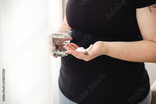 weight loss, dietetic supplements, fat burning, pharmacy, medicine, therapy concept. Overweight woman take pills