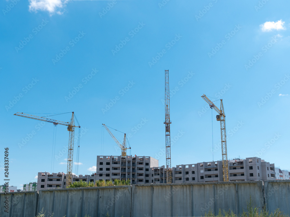 Construction site with many cranes against the sky Construction site with many cranes against the sky