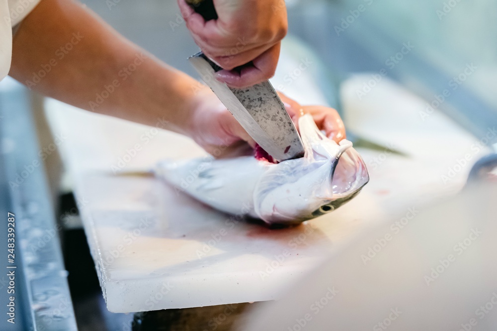 Obraz premium 魚を捌いて調理している様子