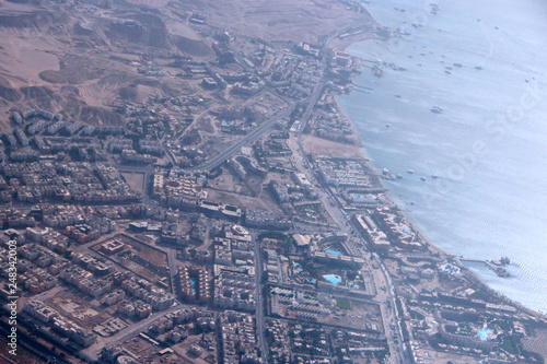 Aerial city view with houses, buildings, seaside in Egypt. Flying above country