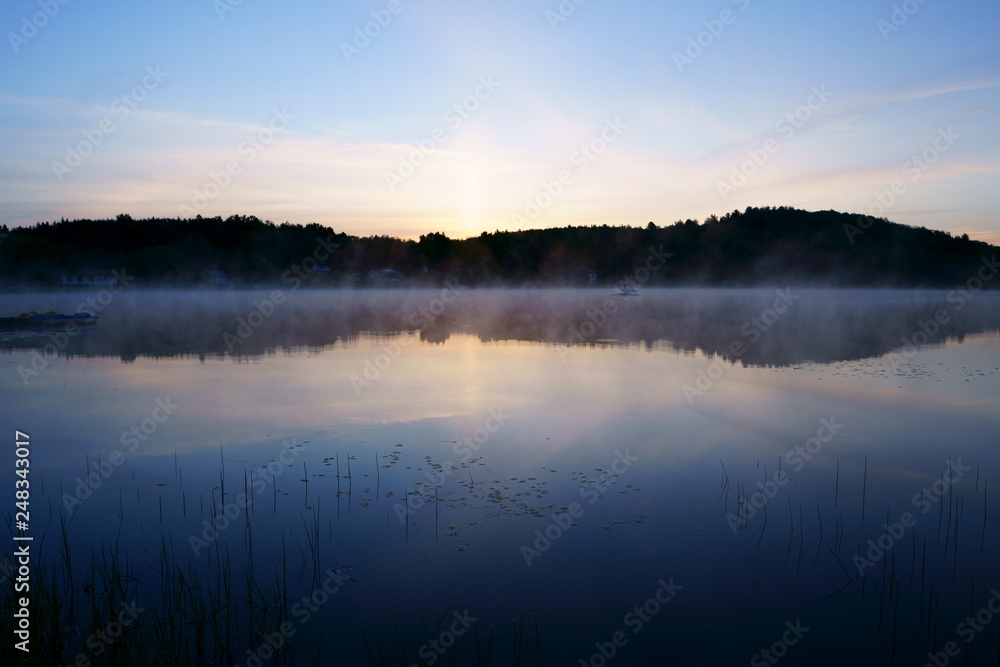 Fototapeta premium Beautiful view on the lake with fog at early morning just before sunrise.