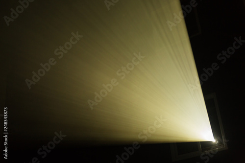 A beam of light from the projector in the cinema. Theatre equipment. Abstract background.