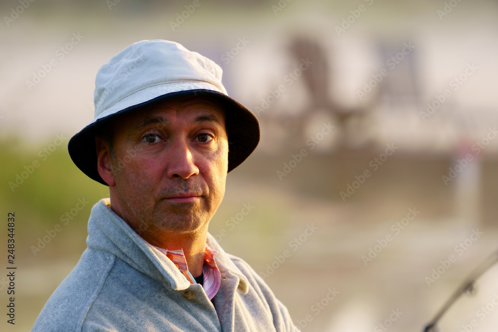 Φωτογραφία Portrait, close up of a caucasian fisherman, 50's, at the lake with fog, early morning just before sunrise