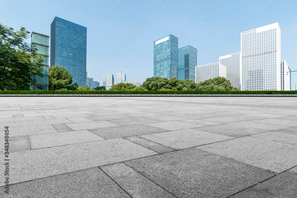 Empty Plaza floor tiles and the skyline of modern urban buildings in Hangzhou..