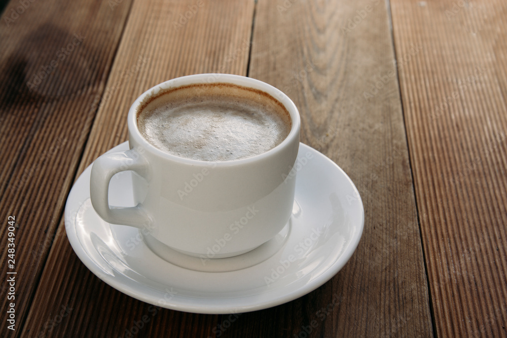 Coffee cup top view on wooden table background. Beautiful morning, outdiir, spring sun light.