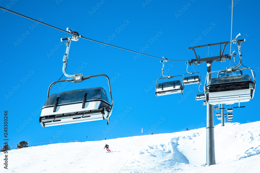 Junger sportlicher Mann fährt Ski, macht Winter Sport in einem Winter Paradis. Schnee bedeckte Berge, blauer Himmel und Farbenfroher Ski Anzug Junger sportlicher Mann fährt Ski, macht Winter Sport in einem Winter Paradis. Schnee bedeckte Berge, blauer Himmel und Farbenfroher Ski Anzug
