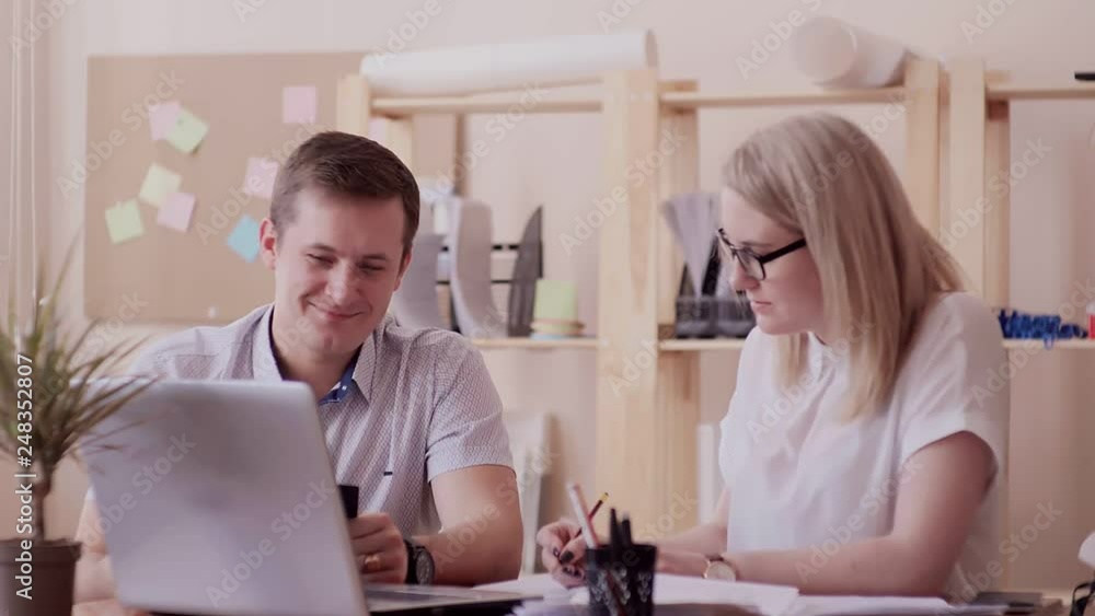 Two people are discussing business project for a laptop Two people are discussing business project for a laptop