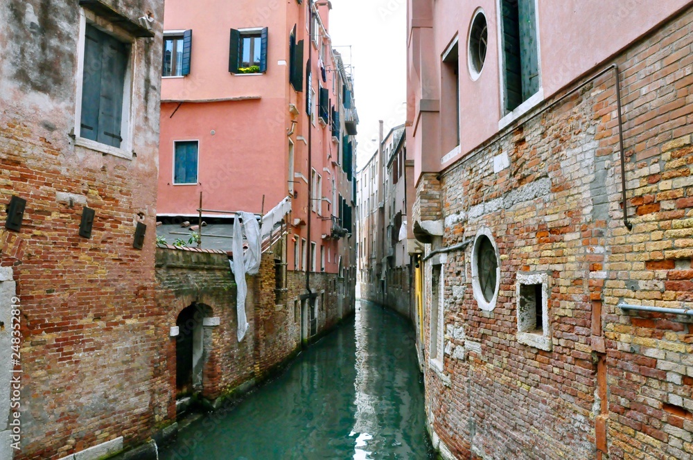 Classic Venice channel view with typical buildings, colorful windows, bridges and boats