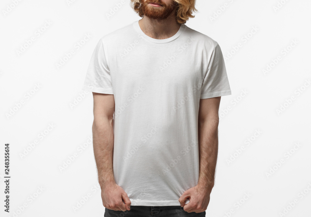 Young european man standing isolated on gray background, wearing blank white t-shirt with copy space for your logo or text Young european man standing isolated on gray background, wearing blank white t-shirt with copy space for your logo or text