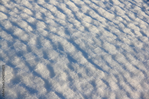 Diagonal wavy texture of the snow dune under the sun - winter background