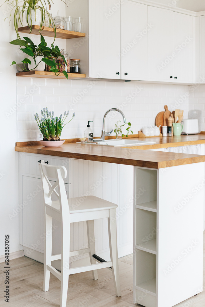 Fototapeta premium Modern white u-shaped kitchen in scandinavian style.
