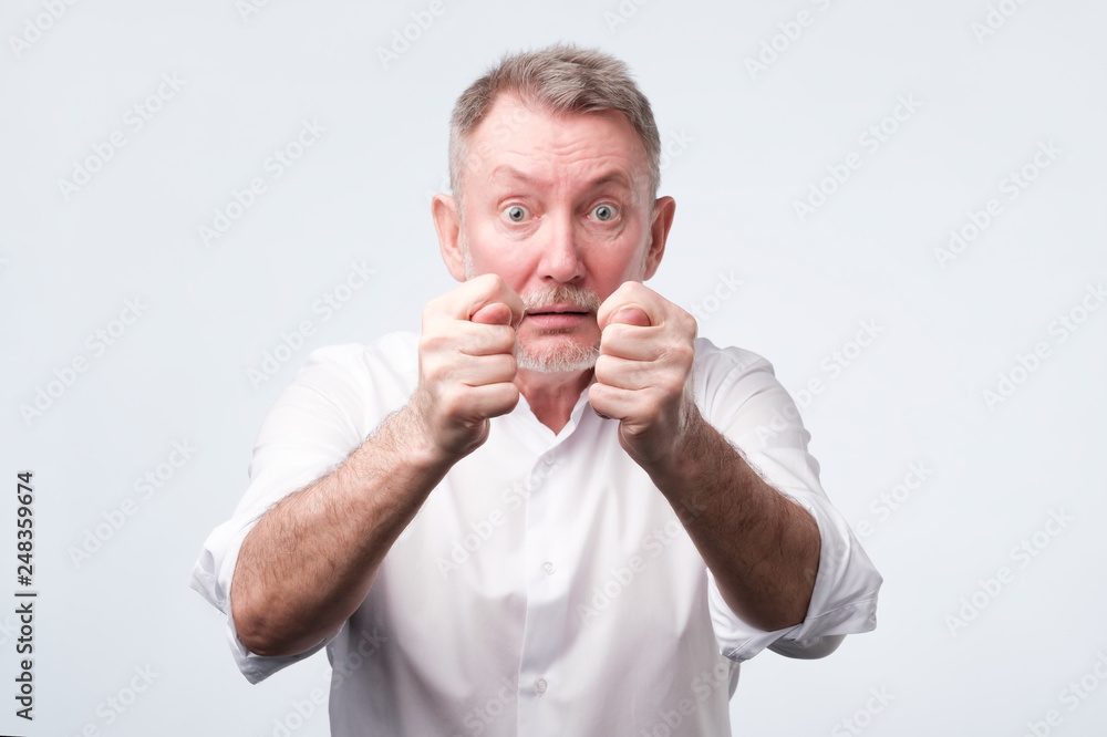Senior man in white shirt shows a fig Senior man in white shirt shows a fig