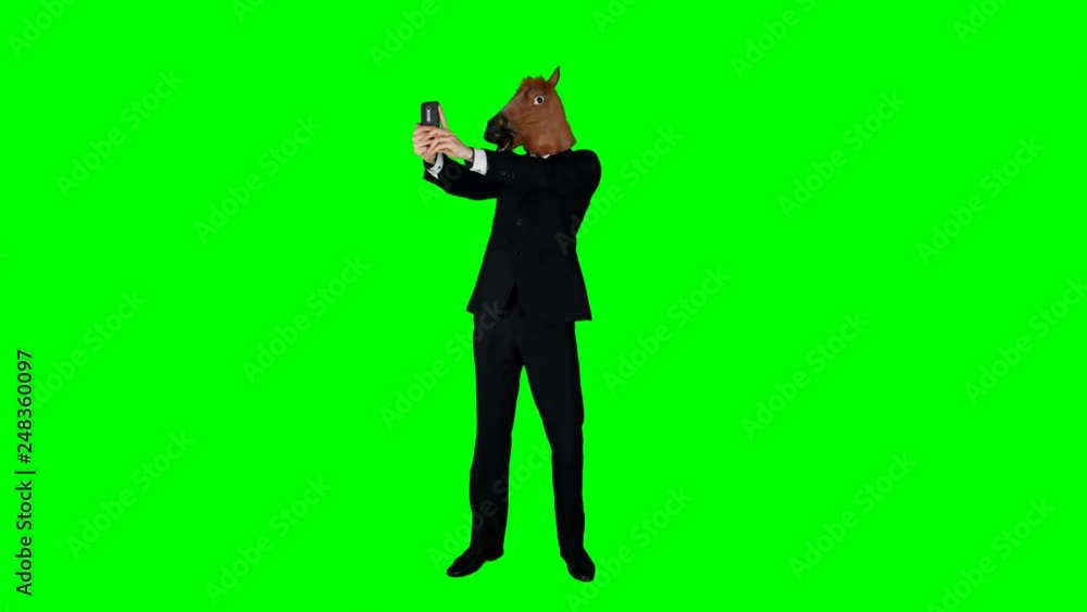 Hilarious Businessman in a Horse Mask Taking a Selfie on a Green Screen Hilarious Businessman in a Horse Mask Taking a Selfie on a Green Screen