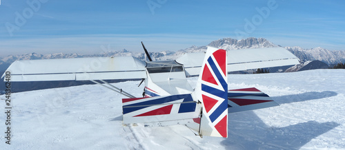 Monte Pora, Bergamo, Italy. A single engined, general aviation light aircraft parked on a snow covered plateau. UK flag colors as livery