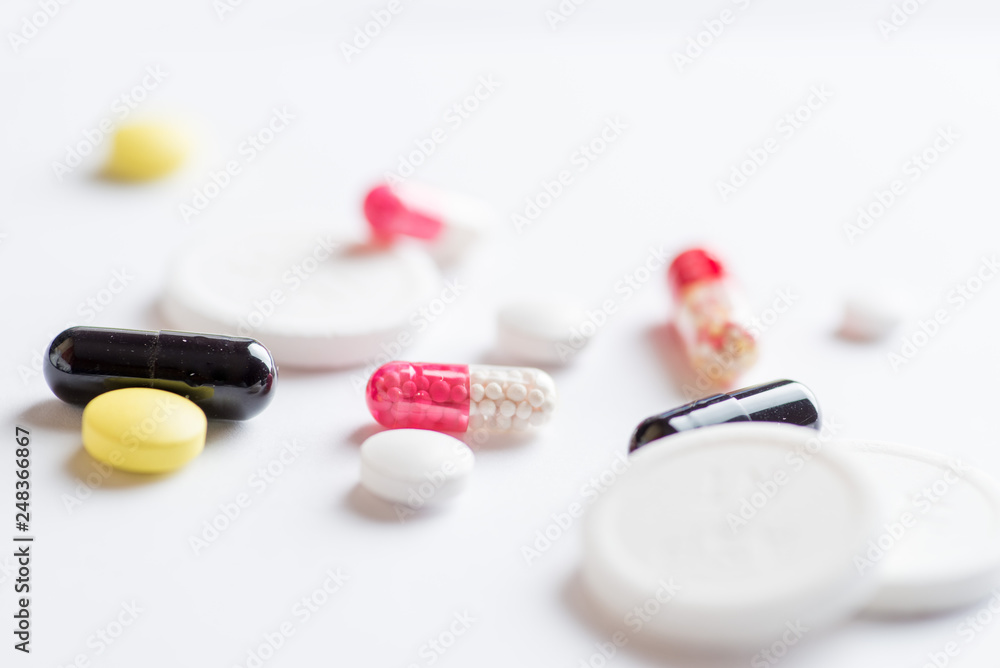 set of multi-colored tablets and capsules on a white background set of multi-colored tablets and capsules on a white background