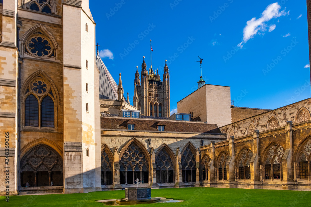 London, United Kingdom - Inner courtyard of the royal Westminster Abbey, formally Collegiate Church of St. Peter at Westminster with the Victoria Tower of the Houses of Parliament in background