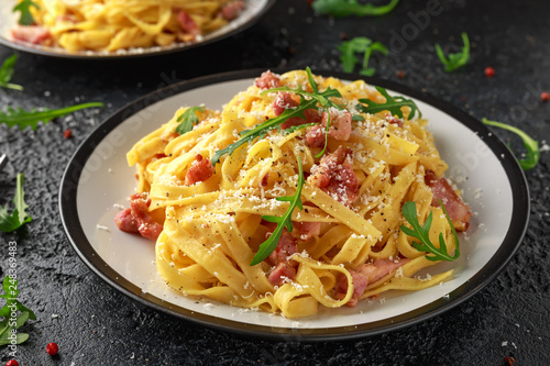 Classic Carbonara pasta, spaghetti with pancetta, bacon, egg, parmesan cheese and green arugula.