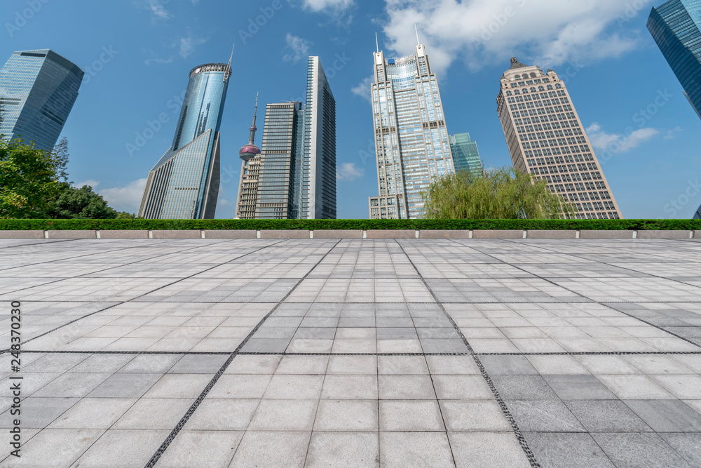 Fototapeta premium Empty square floor tiles and skyline of modern urban buildings in Shanghai..