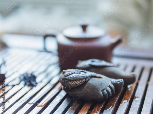 Chinese tea ceremony. Close up view of buddha foot figure and clay teapot on wooden tabletop. Pu erh tea ceremony. photo