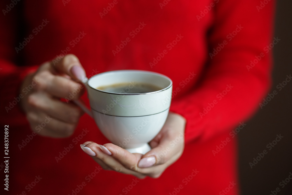 A cup of delicious hot coffee in female hands. Concept drinks, lifestyle, work, background.