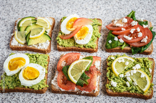 Healthy avocado and egg toasts. Toast, avocado, egg, tomatoes, spinach, cheese Feta, lemon. Organic healthy food. Clean healthy eating