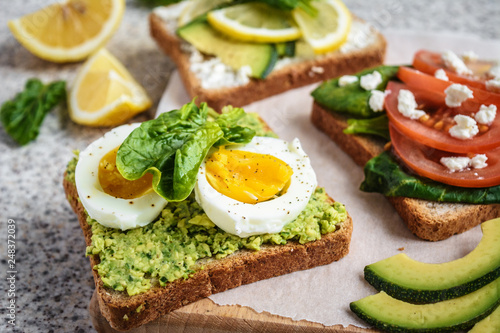 Healthy avocado and egg toasts. Toast, avocado, egg, tomatoes, spinach, cheese Feta, lemon. Organic healthy food. Clean healthy eating