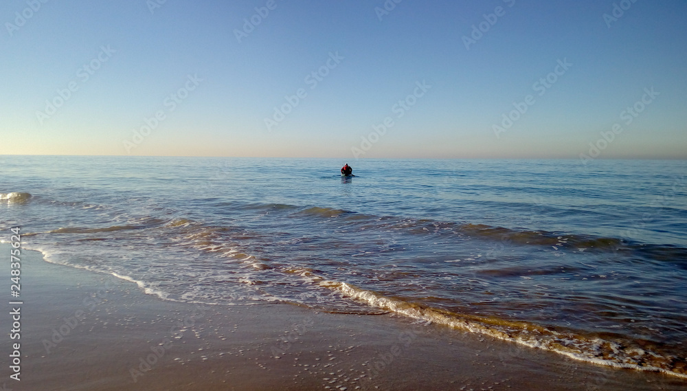 Playa de cadiz con hombre y barca