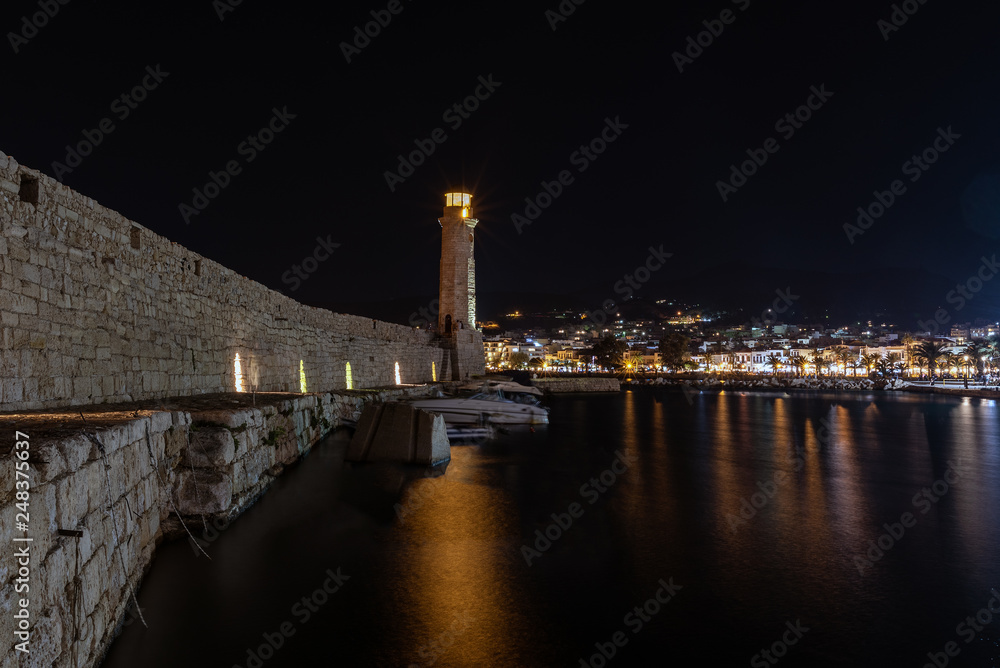 Fortress wall and old lighthouse during the night in port of Rethymno town, Crete island, Greece