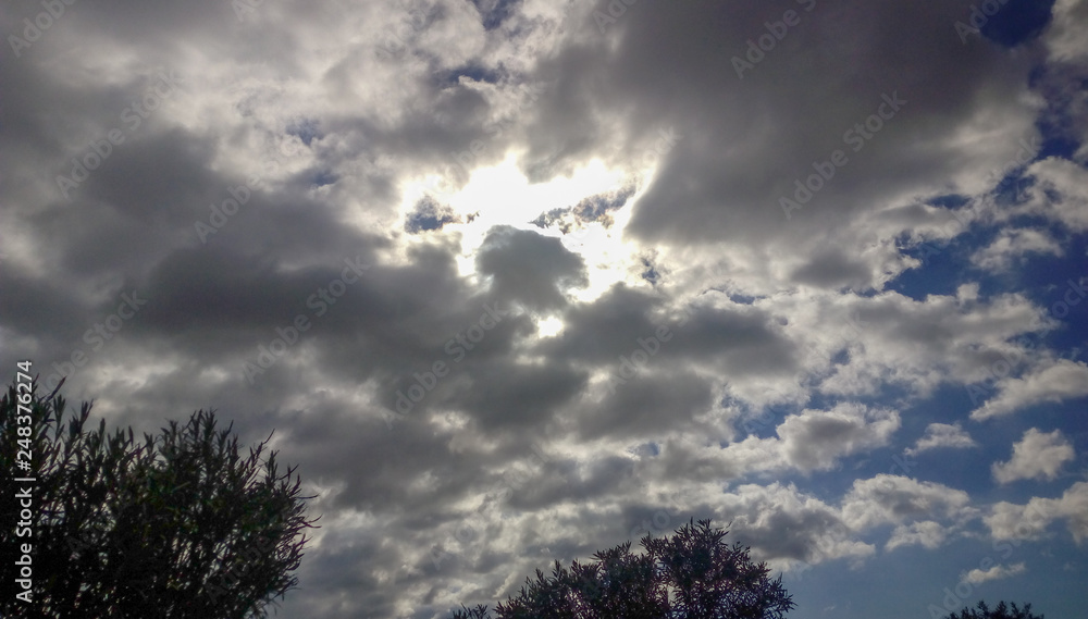 Fototapeta premium Cielo con nube y sol escondido
