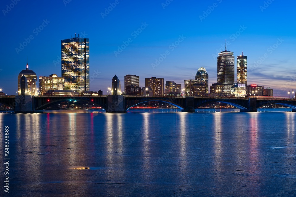 Boston skyline at dusk from cambridge with longfellow bridge and frozen charles river