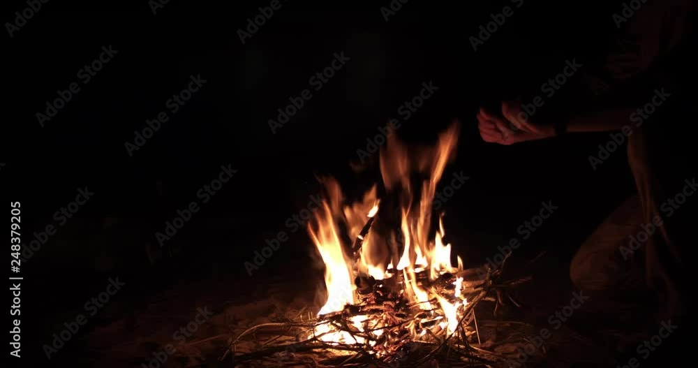 Beautiful campfire in the evening at lake. Fire burning in dusk at campsite near a river in beautiful nature with evening sky at background Beautiful campfire in the evening at lake. Fire burning in dusk at campsite near a river in beautiful nature with evening sky at background