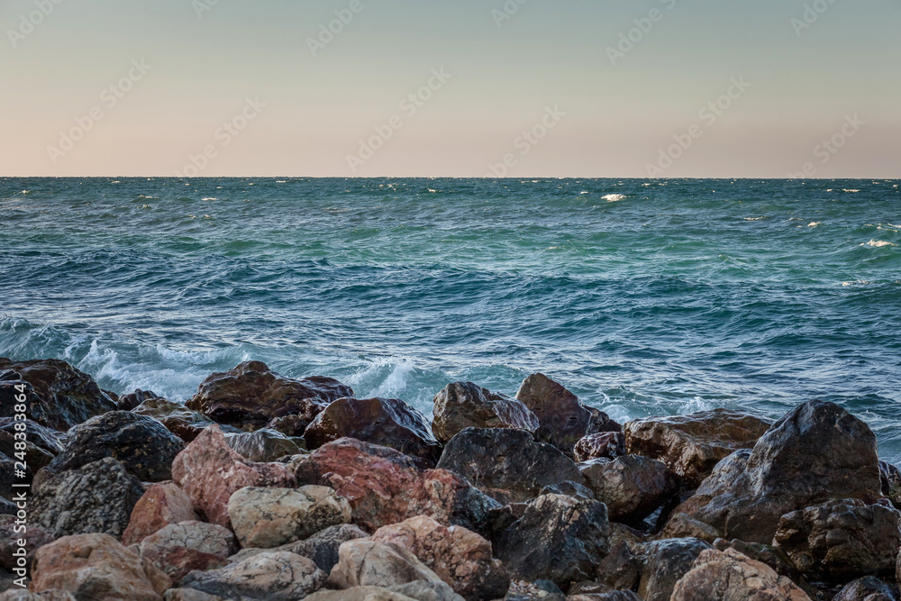 Landscape with stone coast, sea and blue sky