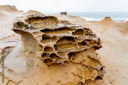 Honeycomb Weathering rock at Yehliu Geopark in Taiwan. Honeycombed rocks refer to the rocks that are covered with holes of different sizes and appear like the honeycombs as a result. photo