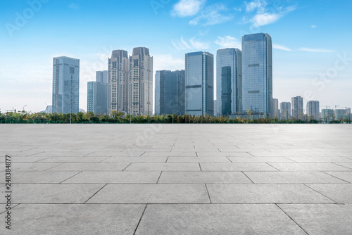 Empty Plaza floor tiles and the skyline of modern urban buildings in Hangzhou..