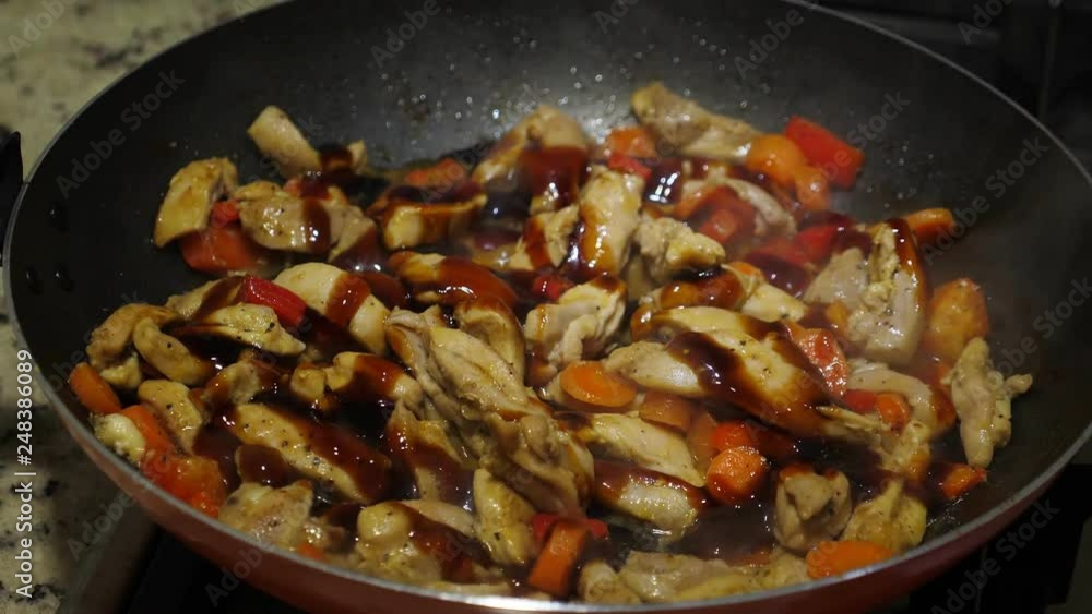 Cooking chicken with teriyaki sauce on frying pan, closeup Cooking chicken with teriyaki sauce on frying pan, closeup