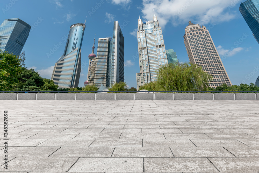 Fototapeta premium Empty square floor tiles and skyline of modern urban buildings in Shanghai..
