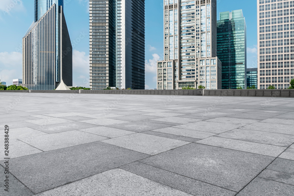 Fototapeta premium Empty square floor tiles and skyline of modern urban buildings in Shanghai..