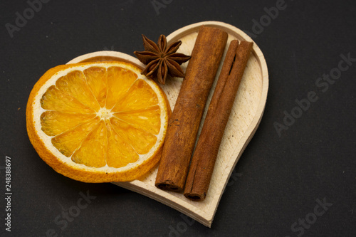 Slices of dried orange with star anise and cinnamon spice isolated against dark