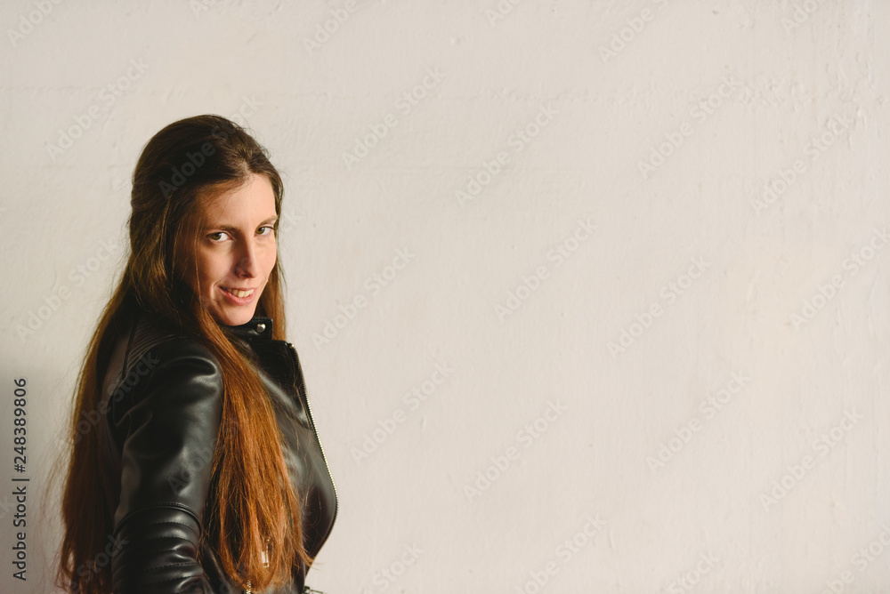 Obraz premium Young millennial woman standing in profile on white and red wall background spoiled with copy space for text, real people looking at camera.