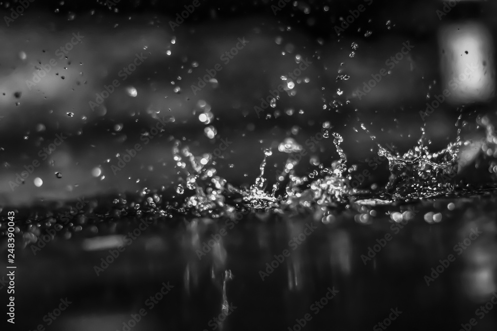 Water drops in the dark outside. Black and white.