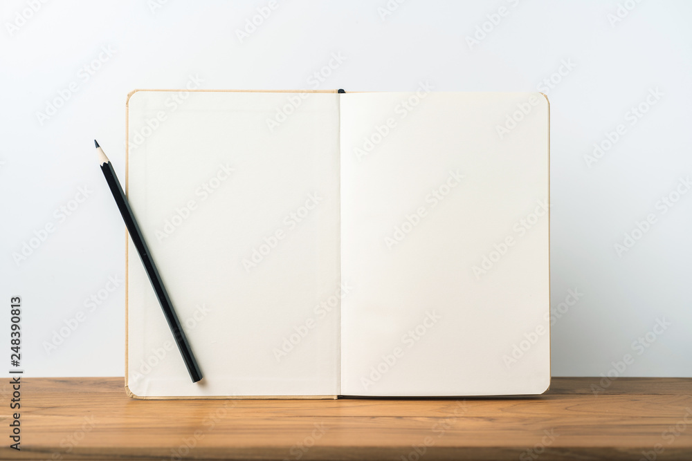 Perspective view of kraft notebook on wood floor Perspective view of kraft notebook on wood floor