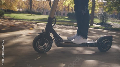 Slow Motion of Modern Man Using Electric Scooter in Sunny Park 4