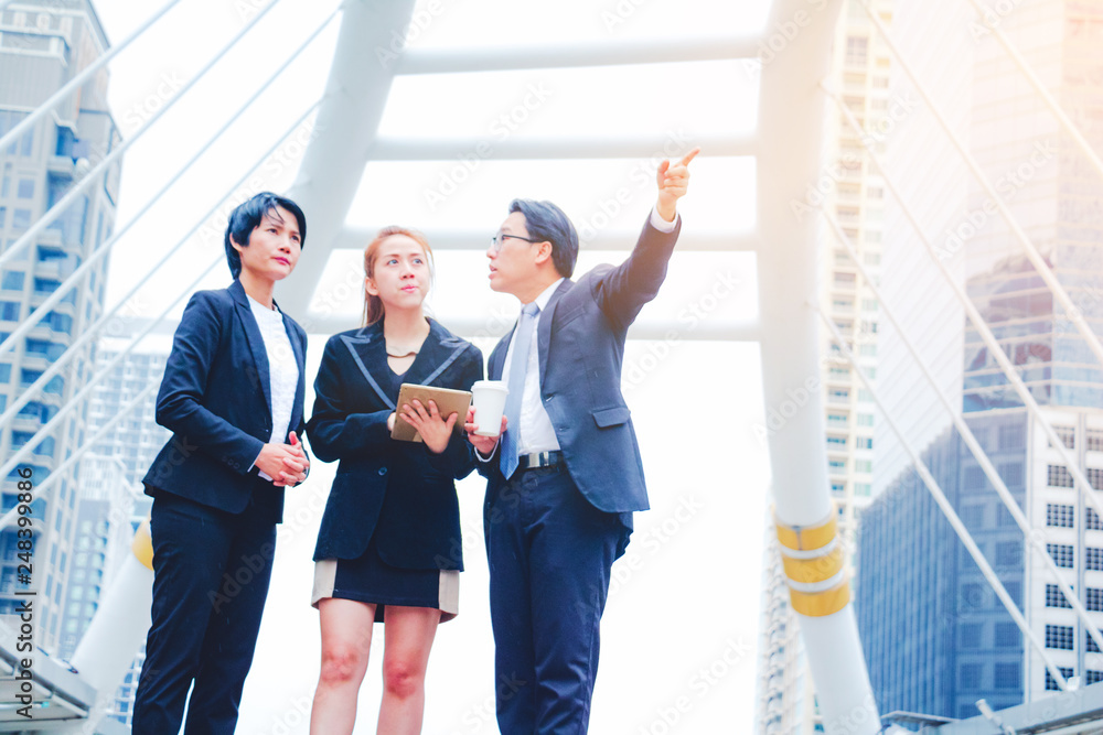 Businessman and teamwork. She play smart phone and talking on town background. He is pointing in to sky and talking Business . Photo concept team work and Business. Businessman and teamwork. She play smart phone and talking on town background. He is pointing in to sky and talking Business . Photo concept team work and Business.
