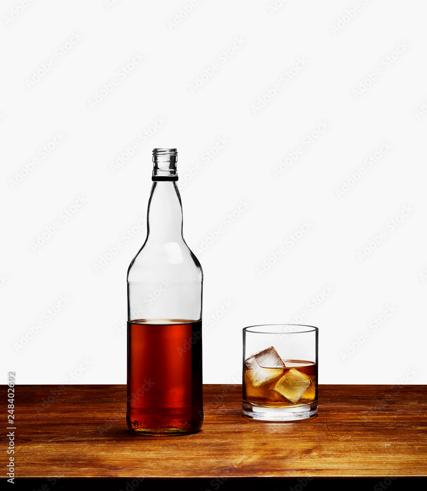 Whisky bottle with glass on wooden table Whisky bottle with glass on wooden table