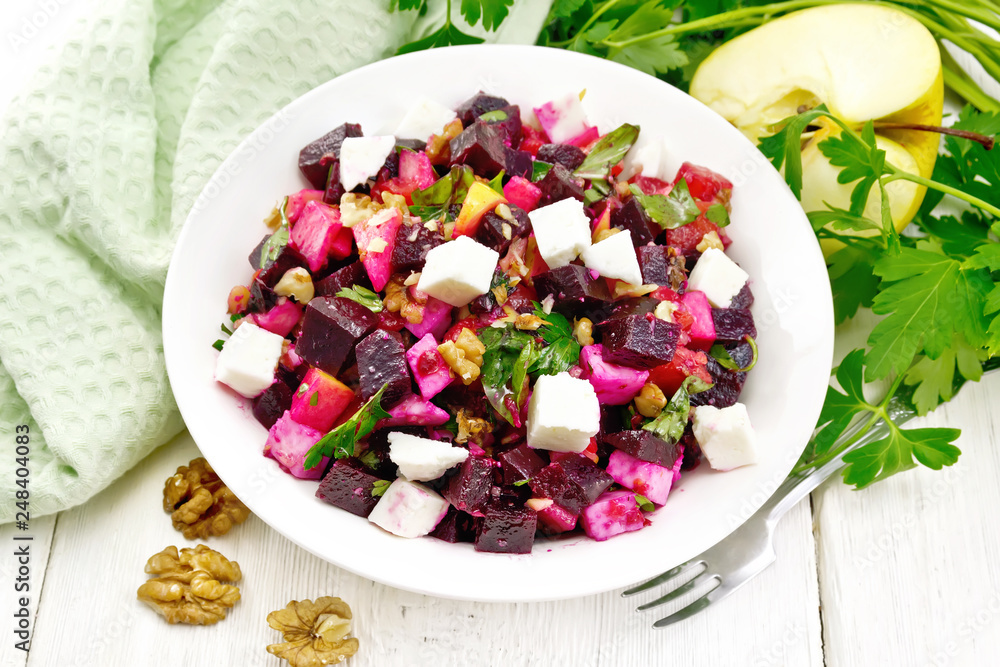 Salad with beetroot and walnuts in plate on board Salad with beetroot and walnuts in plate on board